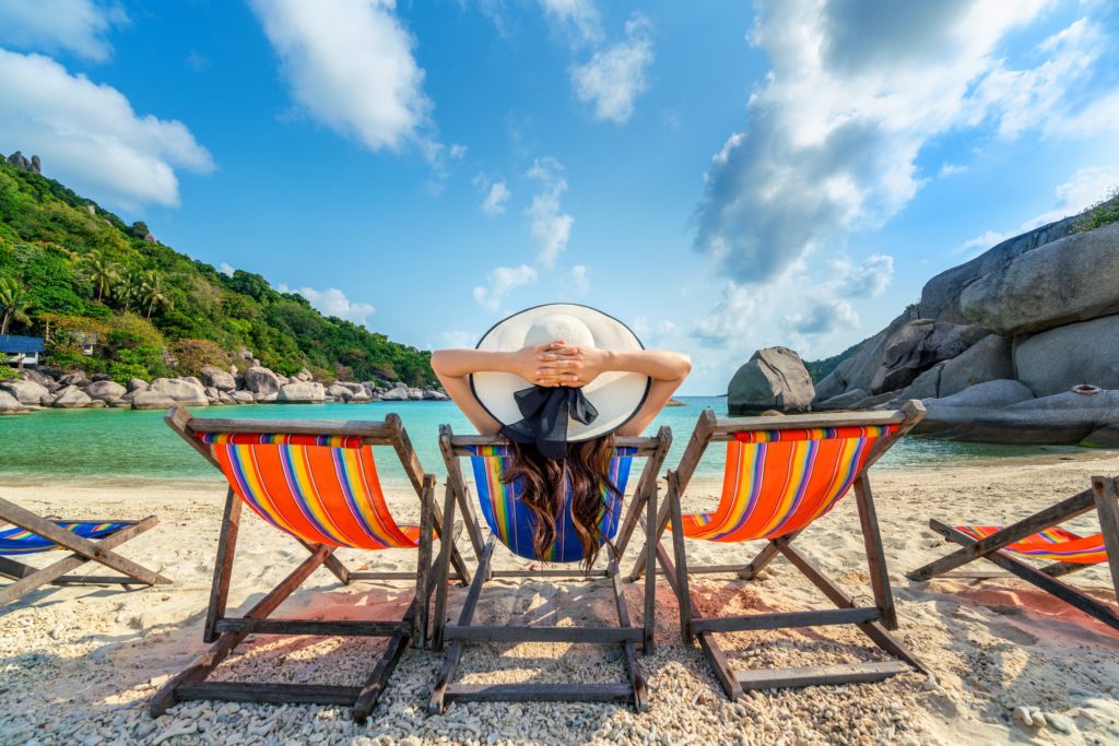 Mujer vacacionando frente a la playa