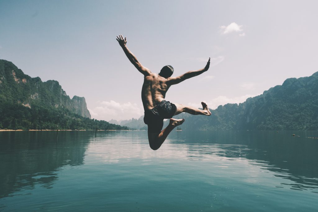 man jumping with joy by lake1